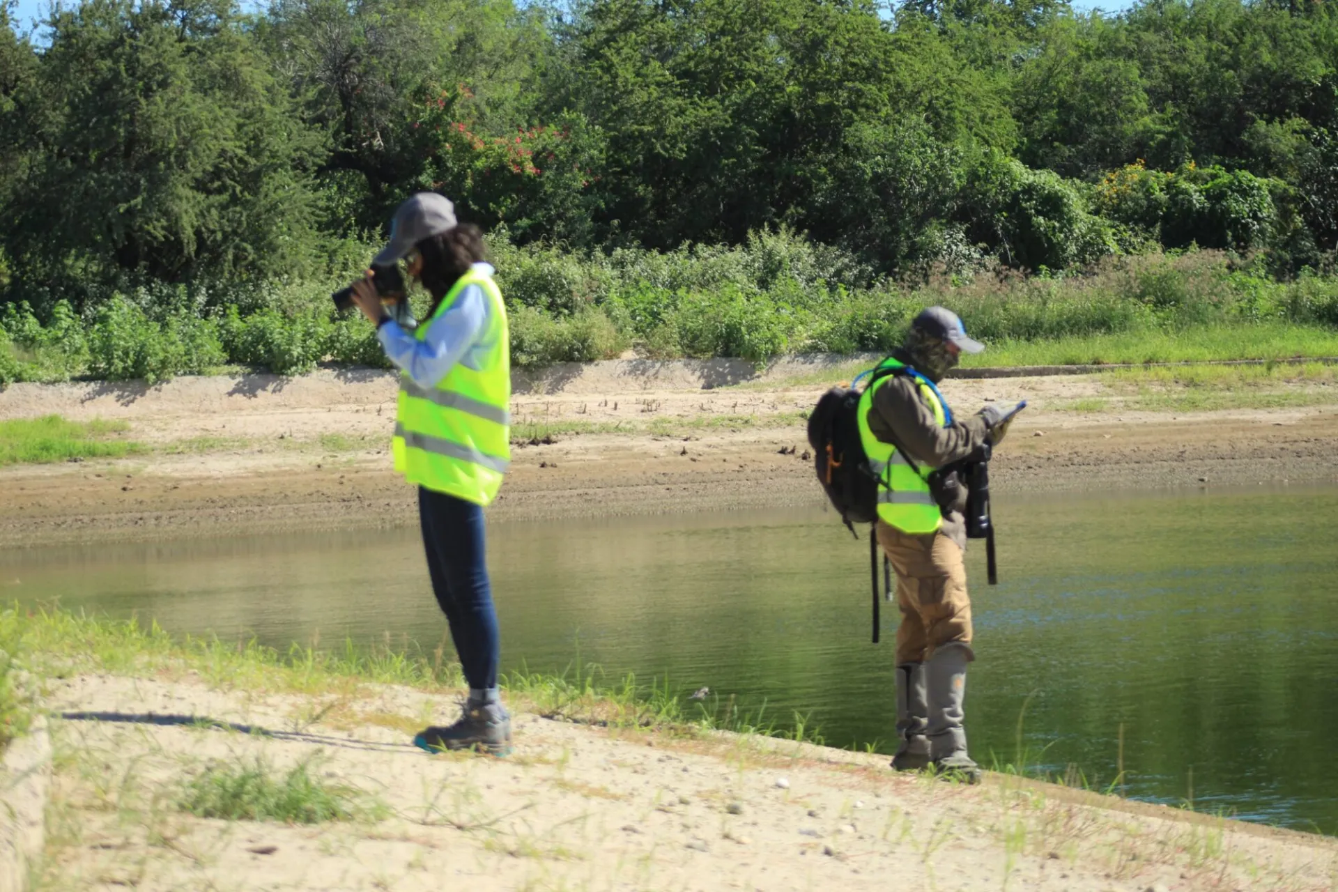 Consultores de GSG realizando levantamiento ambiental en campo junto a un cuerpo de agua